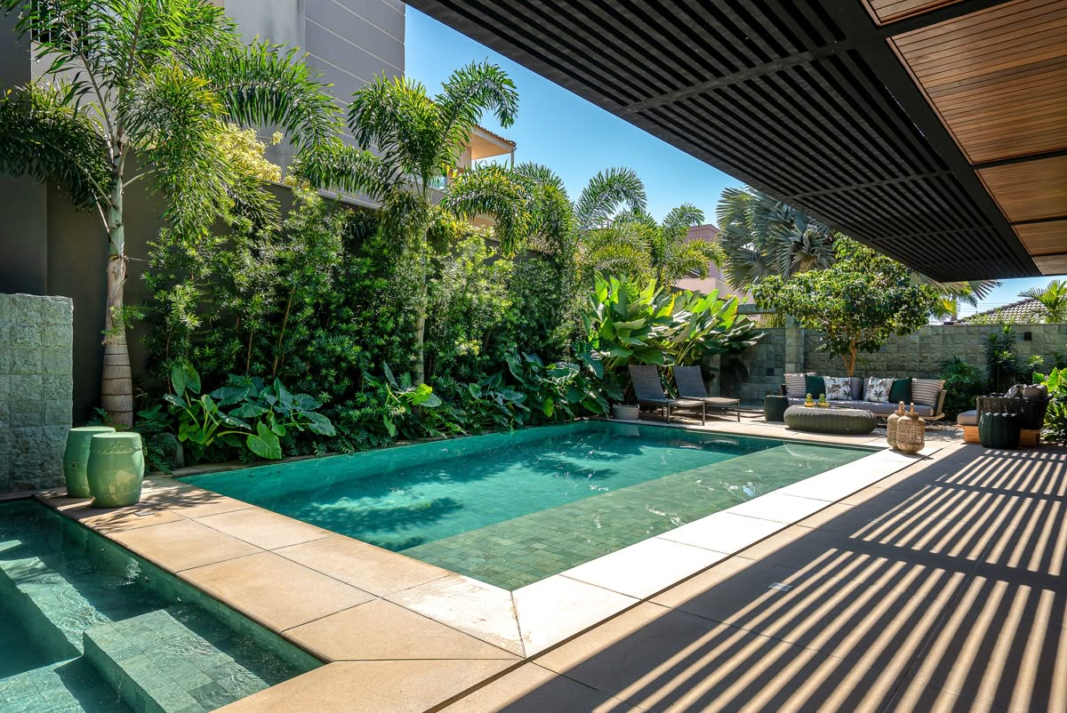Piscina pastilhada verde integrada à arquitetura e ao paisagismo